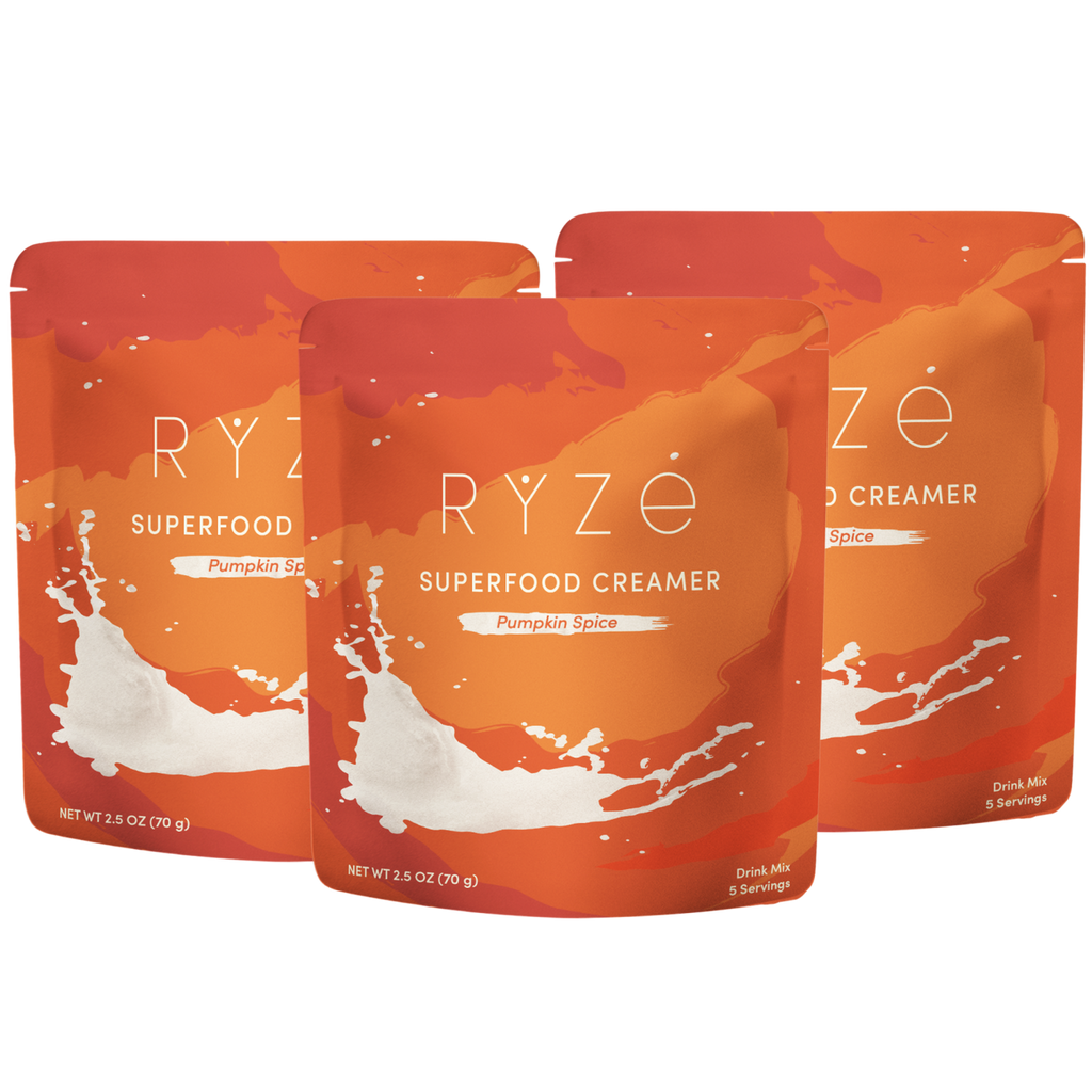 Three stand-up pouches of RYze Superfood Creamer in Pumpkin Spice flavor, arranged in a fan shape on a plain white background.