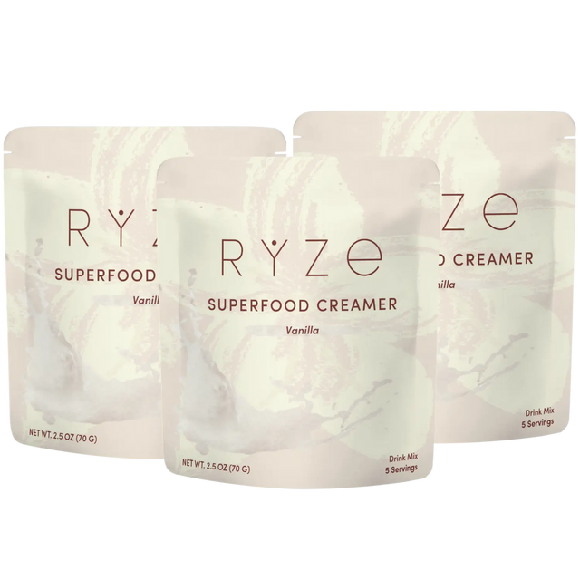 Three stand-up pouches of RYZE Superfood Creamer in Vanilla flavor, arranged in a fan shape on a plain white background.